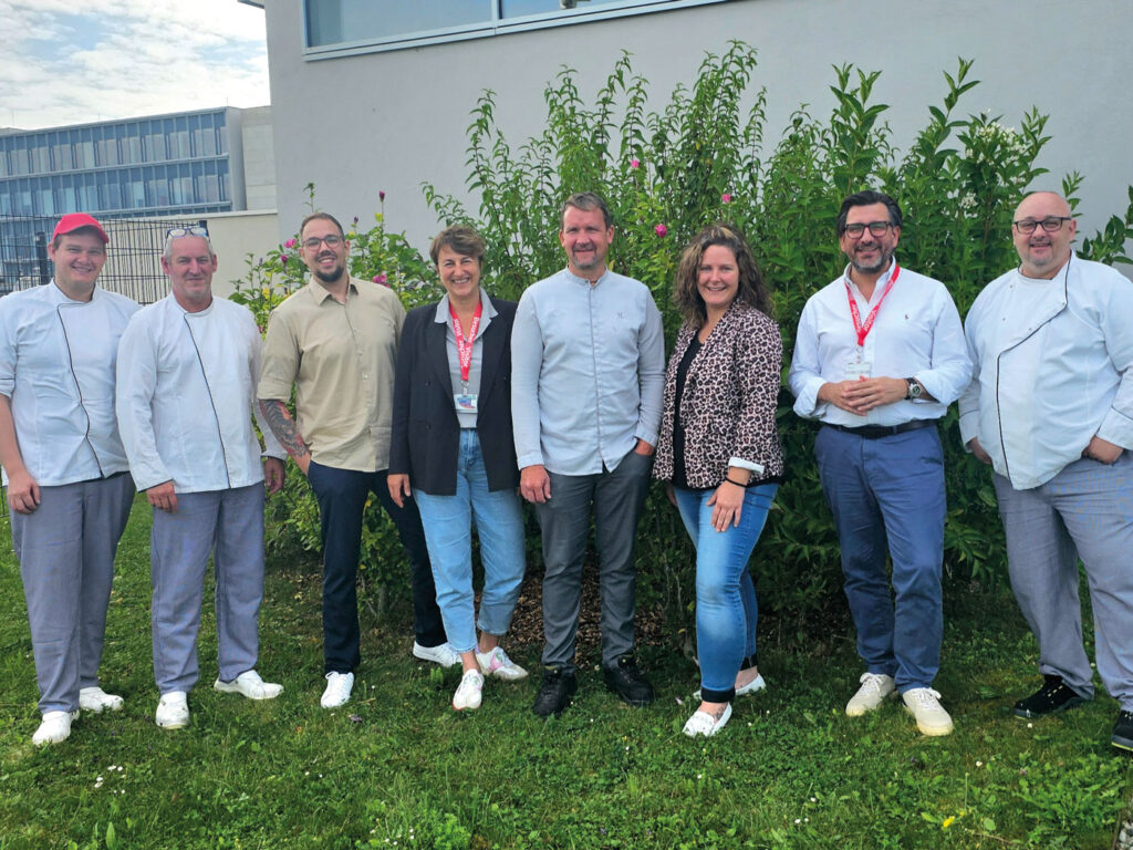 Christian Hamerle, Head of Global Food Service Transformation und einer der Gründer des Food Service Innovation Labs (2. v.r.), Haubenkoch Simon Larese (4. v. r.) und sein Küchenteam begeben sich mit der neuen Menülinie Planet!Based auf den Weg in die kulinarische Zukunft und nehmen die Gäste eines Villacher Betriebsrestaurants dabei mit. © Dussmann